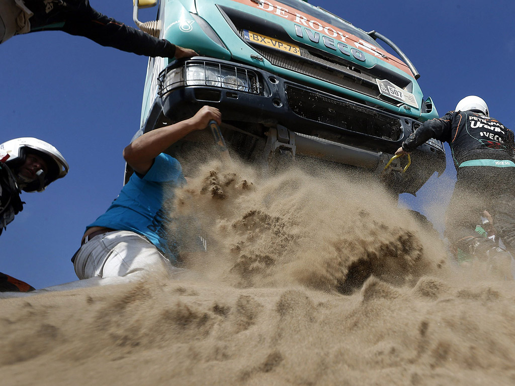 Зрител помага на холандеца Ханс Стейси да премести камиона си от дюна по време на деветия етап на Рали Дакар 2014 в Чили