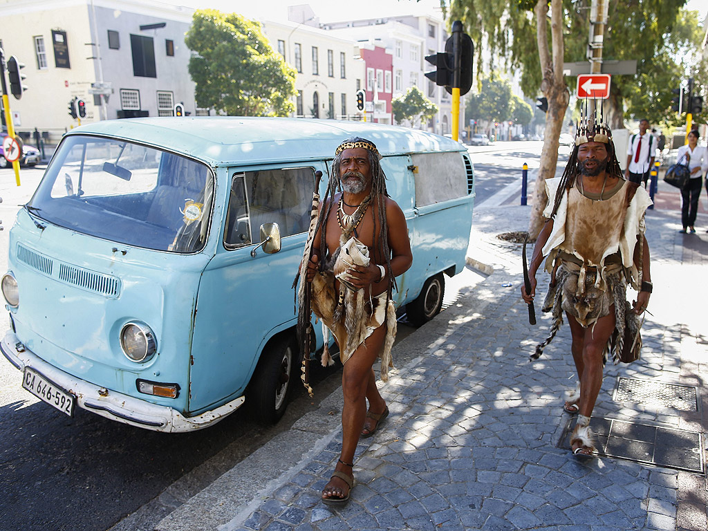 Хора от коренното южноафриканско племе на койсанските, крачат в традиционно облекло през Кейп Таун, Южна Африка. Мъжете вървят към филмово студио, за да бъдат част от документален филм за малцинствените групи.
