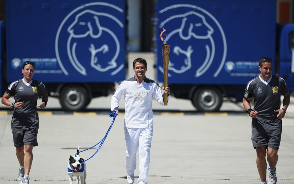 СНИМКИ: Майкъл Оуен носи олимпийския огън, придружен от куче