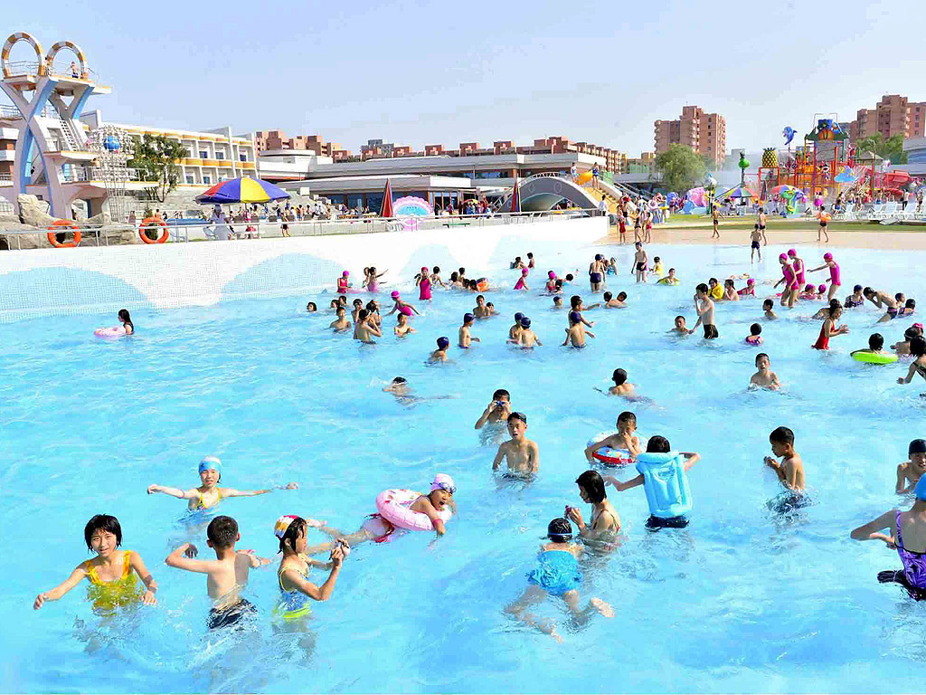 Деца, играят във водата в открит плувен басейн в Пхенян, Северна Корея