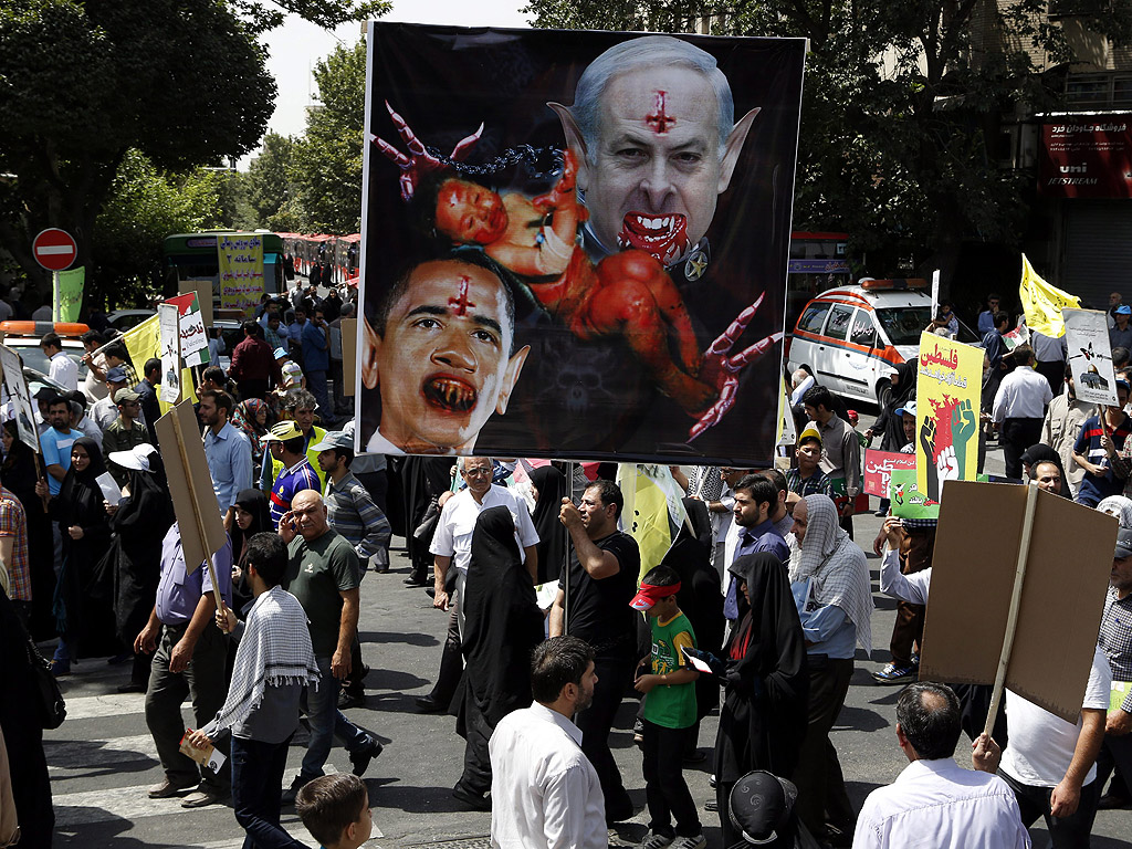 Иранци с карикатура на президента на САЩ Обама и израелския министър-председател Бенямин Нетаняху, по време на анти-израелски митинг в Техеран, Иран. Всяка година Иран в последния петък на месеца на постите Рамазан е ден за солидарност с палестинците.