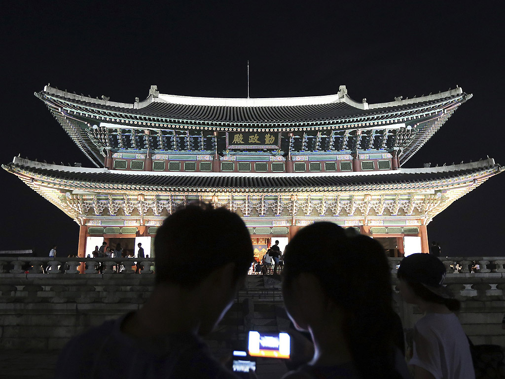 Двойка използва своите мобилни устройства да снима царския дворец по време на династията Чосон (1392-1910), в центъра на Сеул, Южна Корея.