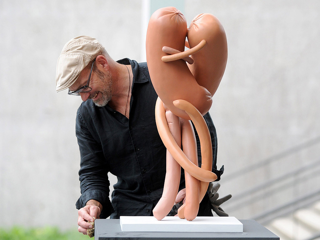 Служител почиства скулптурата на австрийския художник Ервин Вурм "Kiss" изложена в Музея Лембурк в Дуисбург, Германия. Вурм представя творби от серията "Абстрактни скулптури" в музея от 30 август до 28 септември