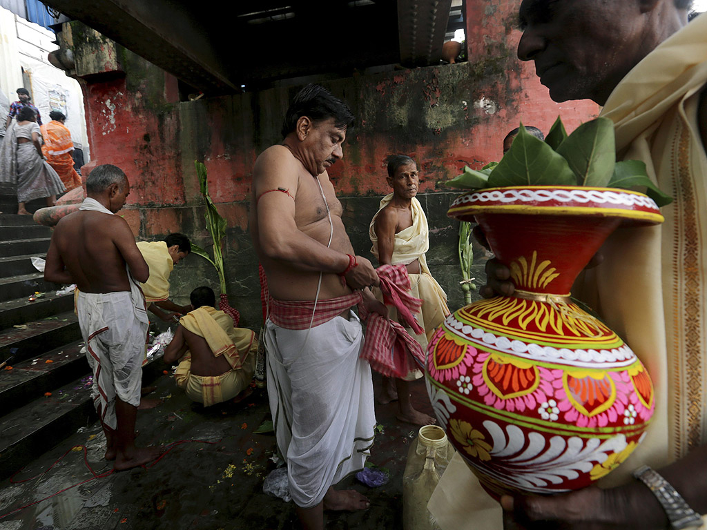 Хиндуистки поклонници извършват ритуали на брега на река Ганг на фестивала Дурга Пуджа в Калкута, Индия