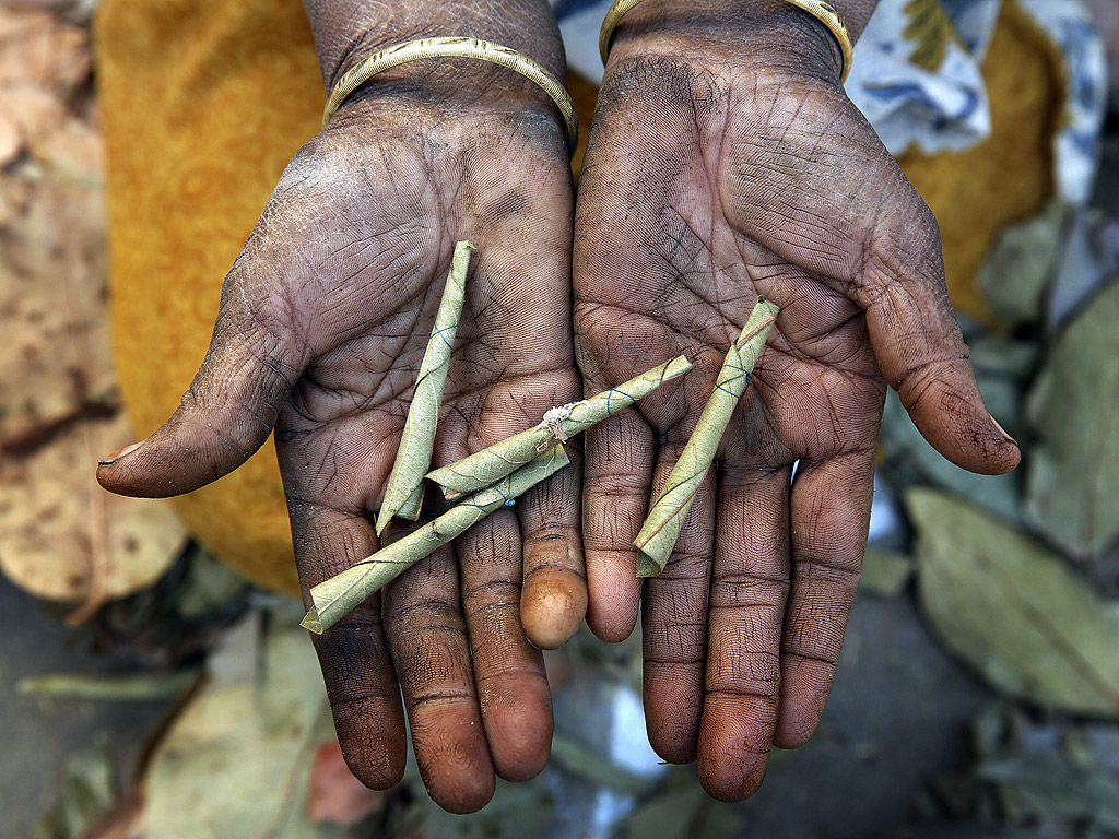 Работничка показва върху наранените си ръце няколко биди – тънка, малка цигара, разпространена в Индия и още няколко азиатски страни. Биди се прави от необработен тютюн, обвит в листа от дърво.