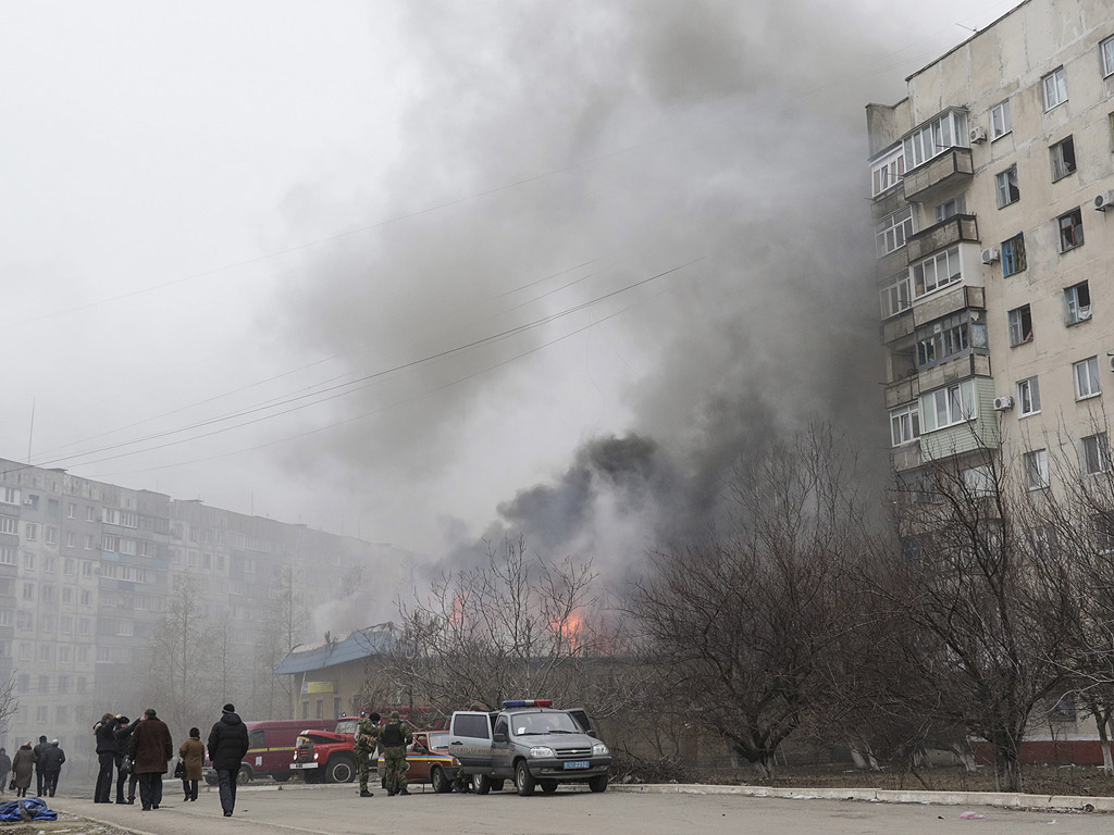 Дим и пламъци се издигат над горяща сграда след обстрела в източния украинския град Мариупол. Петнадесет цивилни души бяха убити и 46 ранени по време на обстрела според доклад на агенция UNIAN