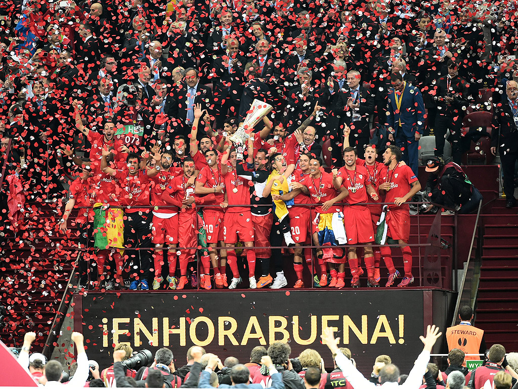 Играчите на Севиля празнуват с трофея, след като спечелиха финала на Лига Европа срещу ФК Днипро на Националния стадион във Варшава, Полша