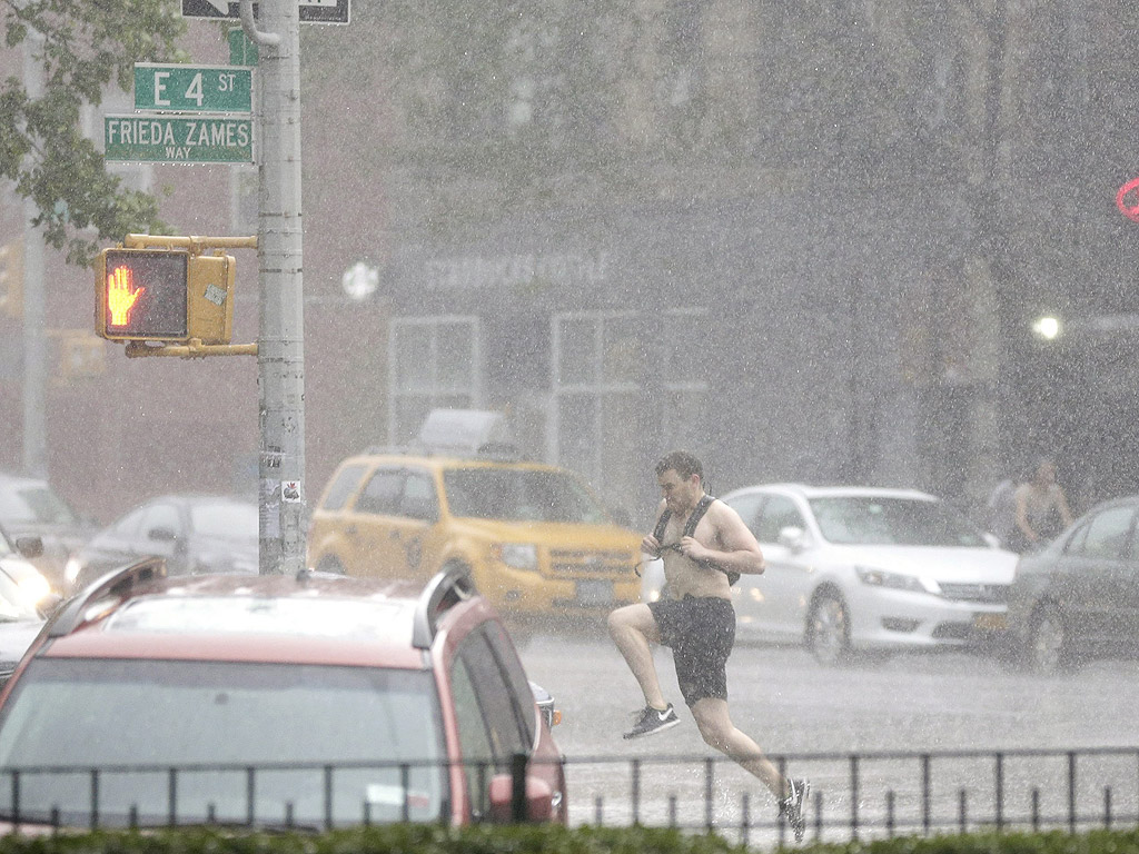 Човек върви ппо време на силен дъжд в Източен Ню Йорк. Проливни дъждове и наводнения се очакват през късните вечерни часове