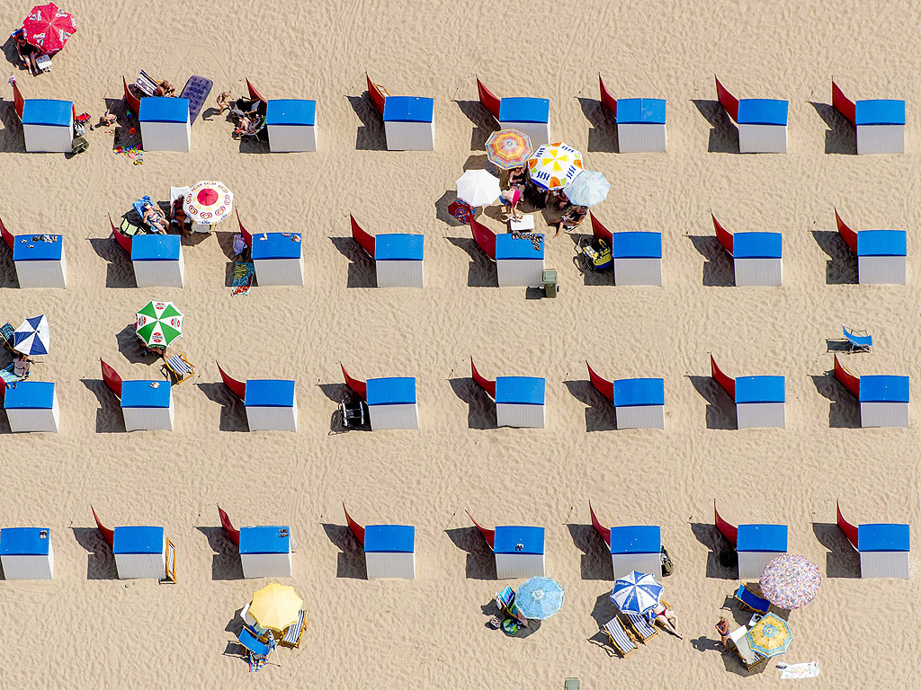 Плажуващи на плажа в Схевенинген, Холандия се радват на топъл летен ден. Метеорологичния институт прогнозира слънчево и горещо време през следващите дни.