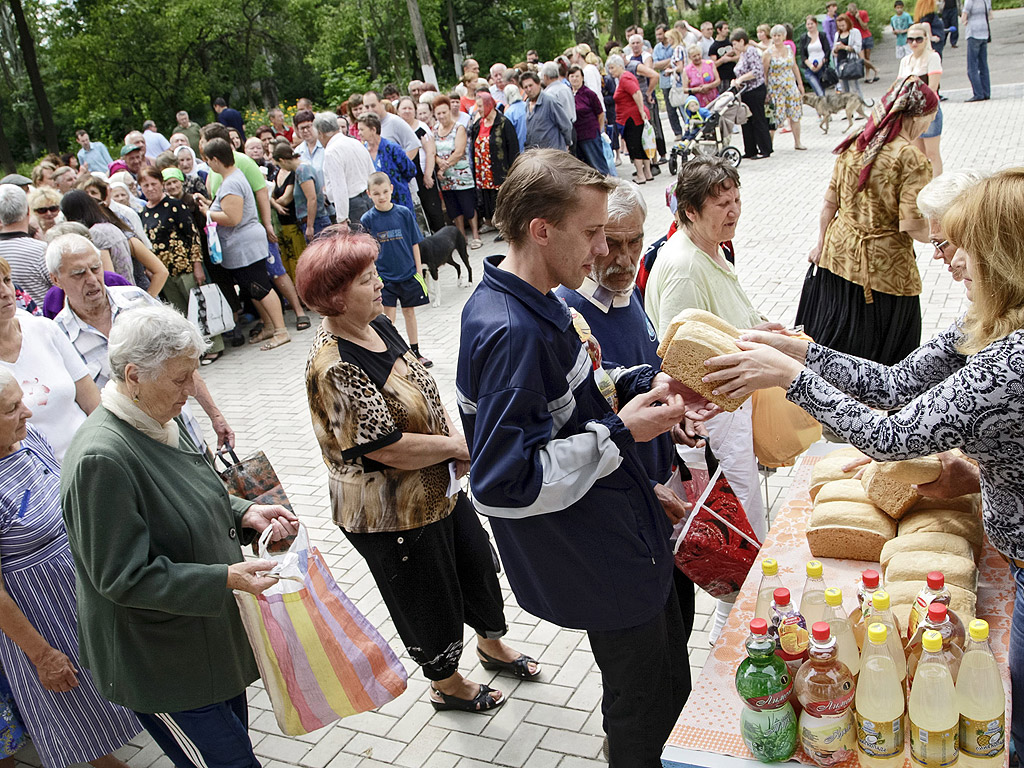Доброволци от самопровъзгласилата се Донецка Народната република разпространяват хляб за граждани в Донецк, Украйна.