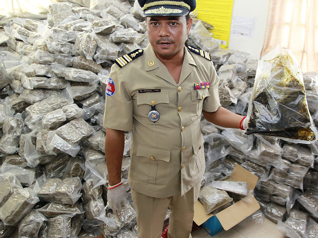 Камбоджански полицай държи торба с марихуана в анти-наркотичния отдел в Пном Пен, Камбоджа. Камбоджанските сили за борба с наркотиците арестуваха трима трафиканти на марихуана
