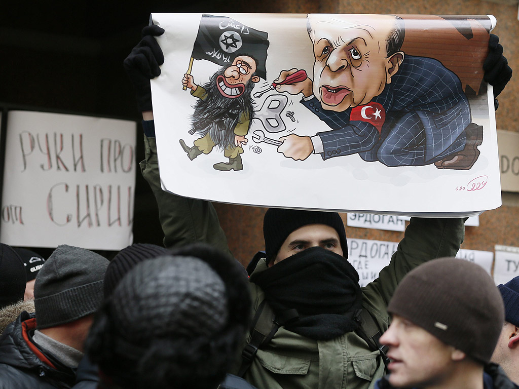 Руснак протестира с плакат, показващ Турският президент като асистент на ИДИЛ, на митинг пред турското посолство в Москва, Русия.
