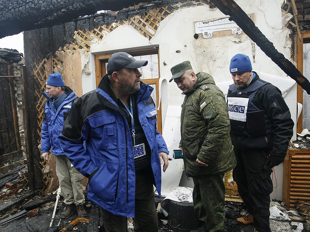 Представители на Организация за сигурност и сътрудничество в Европа (ОССЕ) и руски участник от Съвместния център за контрол и координация инспектира повредена къща след обстрела от украйнска страна в квартал Октяберски в близост до международното летище на Донецк. Повече от 6000 души са били убити в източната част на Украйна, след като местното население и украинската армия започнаха битка през април 2014 г., според оценки на ООН.