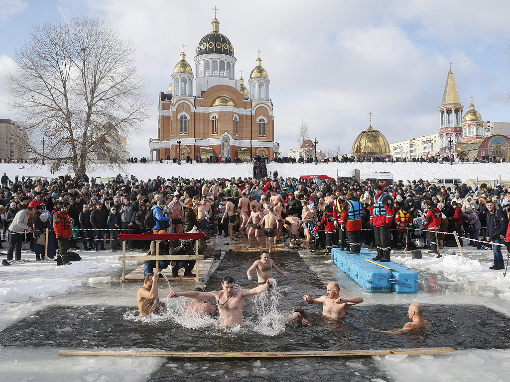 Православни вярващи се къпят в студена вода по време на Богоявленски тържества в Киев, Украйна. По време на Богоявление, някои хора вярват, че водите имат специални лечебни свойства и могат да бъдат използвани за лечение на различни заболявания, а много от тях правят ледени бани, като част от празника