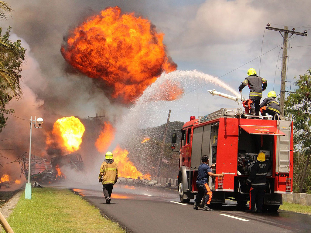 Пожарникари се опитват да загасят контейнери с газ (LPG) на улица в град Байбай, остров Лейте, Филипините. Контейнерите на камион, доставящ LPG експлодираха, по пътя към Масин Сити