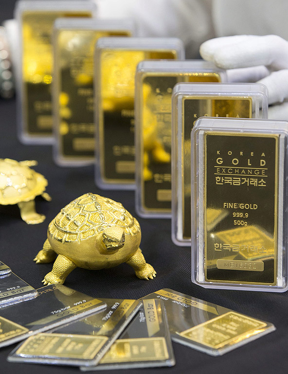Златни кюлчета, показвани от служител на борсата на Корея в Сеул, Южна Корея. Цената на златото на грам скочиха до 50,200 вона (около 42.55 щатски долара) на фона на Brexit, това е първото преминаване на цена от 50,000-вона, след март 2014
