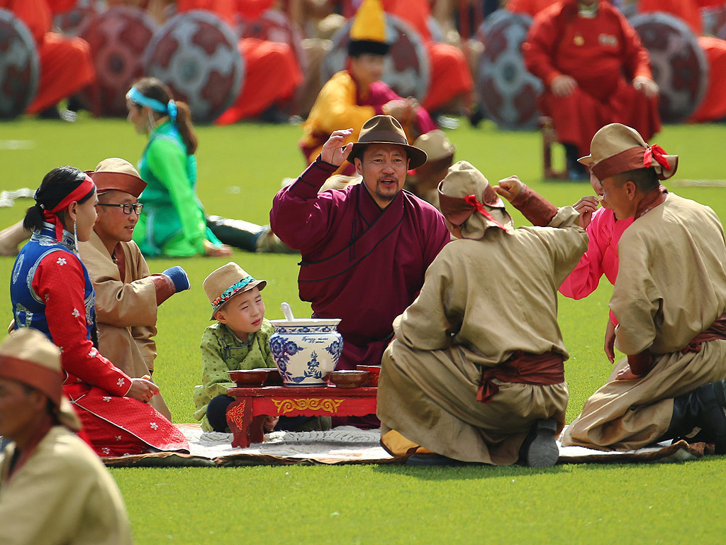Монголци в традиционна носия по време на церемонията по откриването на фестивала Naadam в Улан Батор, Монголия. Ежегодния фестивал Naadam се провежда от 11 до 13 юли, е най-важният празник в годината и традиционен монголски конкурс за забавления и игри с конни надбягвания, борба и стрелба с лък - известен като "трите игри на мъжа"
