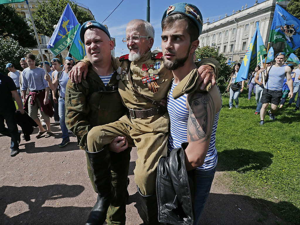 Руски бивши парашутисти носят на ръце възрастен ветеран, за годишния им празник в центъра на Санкт Петербург, Русия. Парашутните войски са създадени преди 86 години, Празникът на парашутистите се чества ежегодно на 2 август в Русия