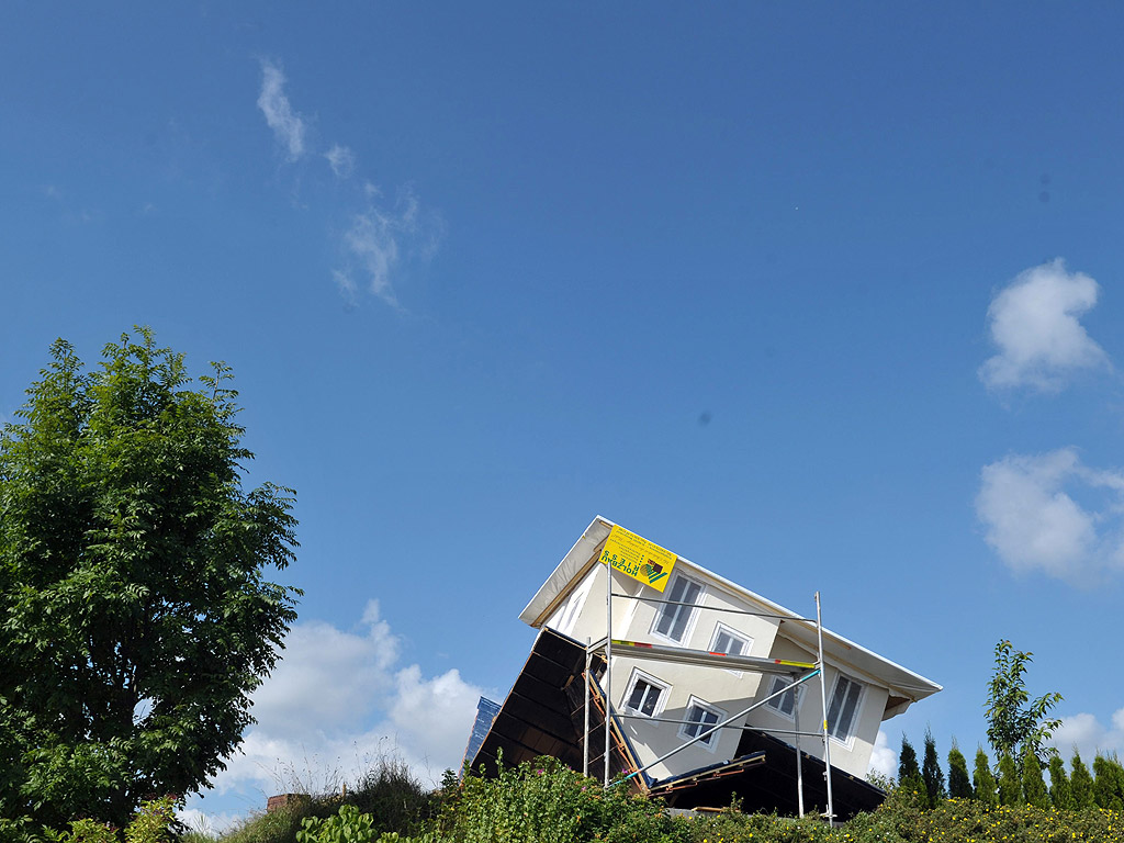 Къща с главата надолу в Щоцард, Германия. Собственика на дома го е направил в мащаб 1: 2 като версия на своя дом с главата надолу в градината си за навес