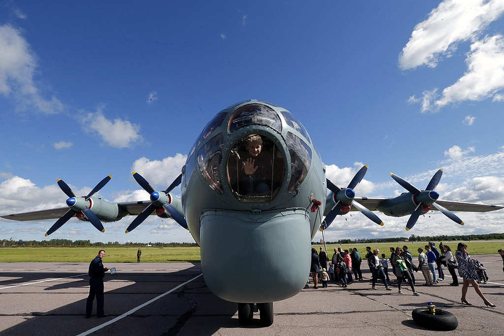 Посетители разглеждат руския Antonov AN-12 по време на Авиошоу близо до Санкт Петербург, Русия, за Деня на руските ВВС