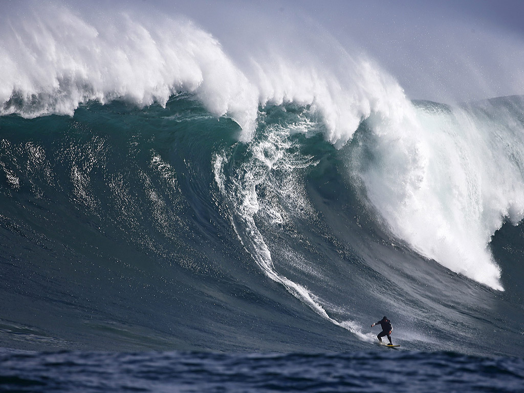 Сърфиста от Южна Африка Анди Мар, под вълната в Атлантическия океан близо до Кейптаун, Южна Африка. Сезонът на големите сърф вълни е в своя пик