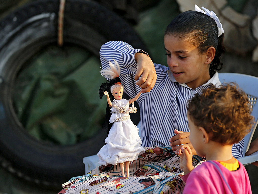 Палестинско момиче играе с куклата си, преди да отиде на училище в село на Западния бряг, южно от Хеврон.