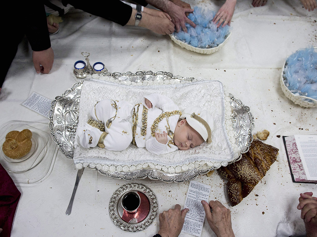 Ултра ортодоксални евреи са се събрали около новородено бебе в сребърна купа за ритуала изкупуване на първия роден син в Йерусалим, Израел