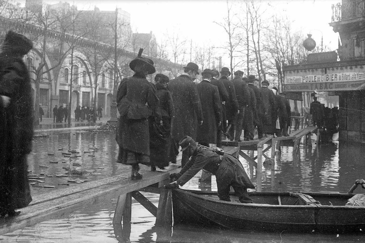 В края на януари 1910 г. след месеци на обилни валежи във Франция, в Париж река Сена пълни канализационните канали, тунелите на метрото, проправя си път до мазетата на хората и пропива напълно почвата.
За разлика от близките градчета, в които буйната река излиза от коритото си и залива всичко заобикалящо я, в Париж тя сякаш извира от самия град, за да го наводни.
За 10 дни водата достига до най-високото си ниво, а на 35-ия изчезва напълно. За щастие наводнението не отнема нито един живот. За сметка на това нанася щети на стойност над 400 млн. франка, равняващи се днес на 1.5 млрд.