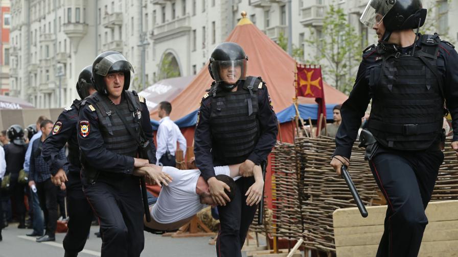 Полицията отвежда арестант по време на демонстрацията в Москва