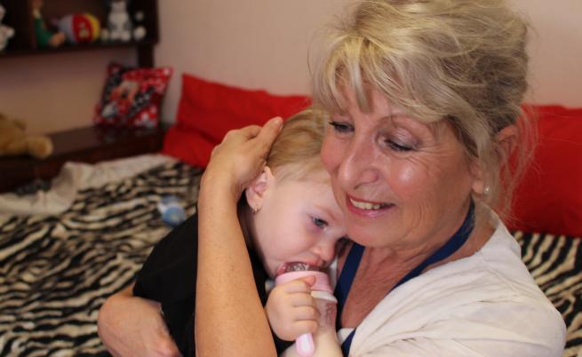  Патронажната сестра Нина Димова гушка едно от бебета на Галя Елена. Източник: УНИЦЕФ България 