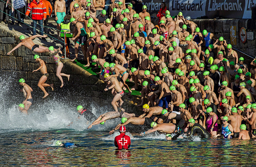 Плувците се хвърлят във водата в началото на традиционното коледно състезание в Хихон, Испания, 25 декември 2017 г. 