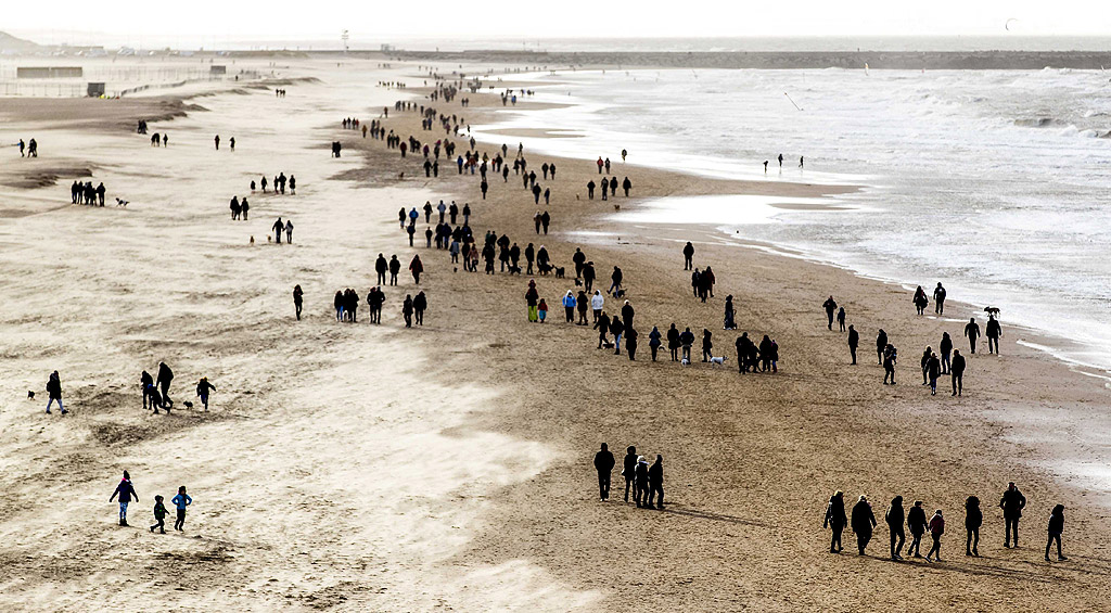 Туристи и местни хора се разхождат по плаж в Холандия, 26 декември 2017 г.