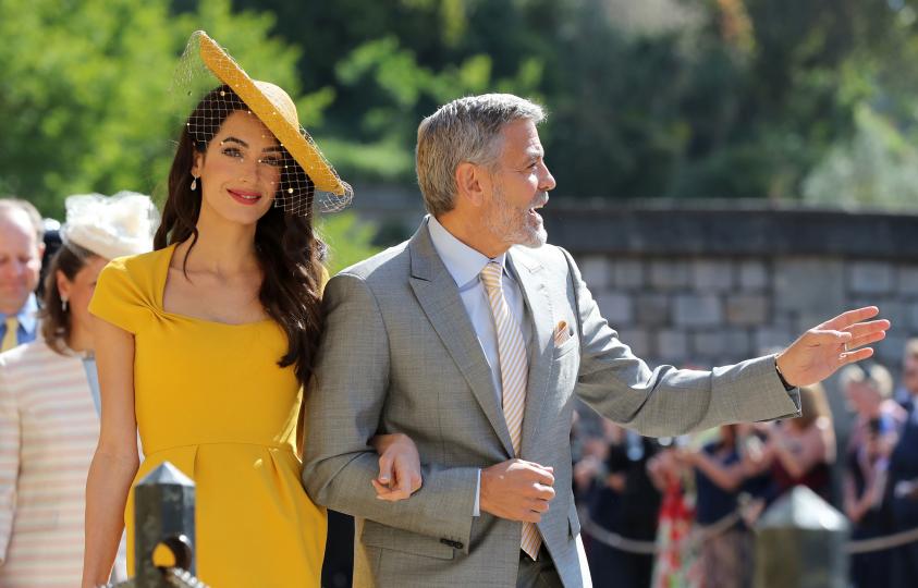 <p>Джордж Клуни, с чудесен официален костюм, и Амал - с невероятна жълта рокля и шапка.&nbsp;Обожаваме жълто и мислим, че Амал Клуни е взела чудесено решение при избора си на тоалет за кралската сватба.</p>
