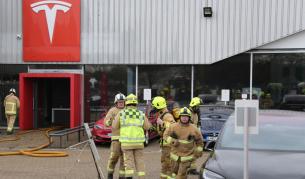 Пожарникари потушават пламналото дилърство на Tesla в Краули, Западен Съсекс, Англия.