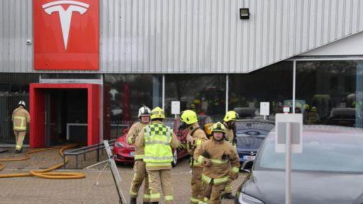  Пожарникари потушават пламналото дилърство на Tesla в Краули, Западен Съсекс, Англия. 