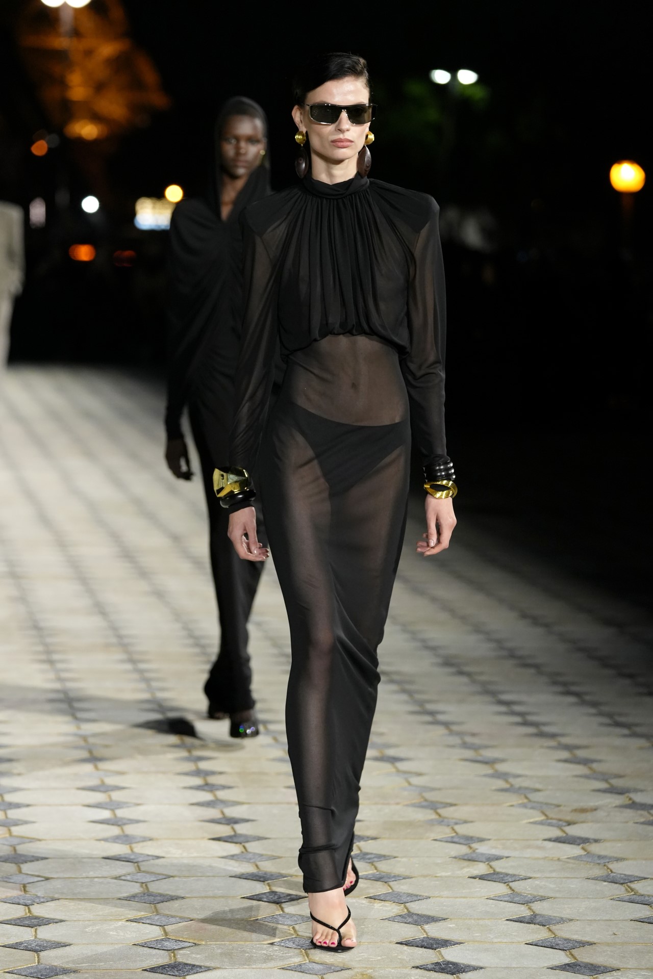 Френската модна къща "Ив Сен Лоран" организира дефиле на открит подиум, озарен от светещата Айфелова кула, за да представи колекция от елегантни вечерни облекла на дизайнера Антъни Вакарело