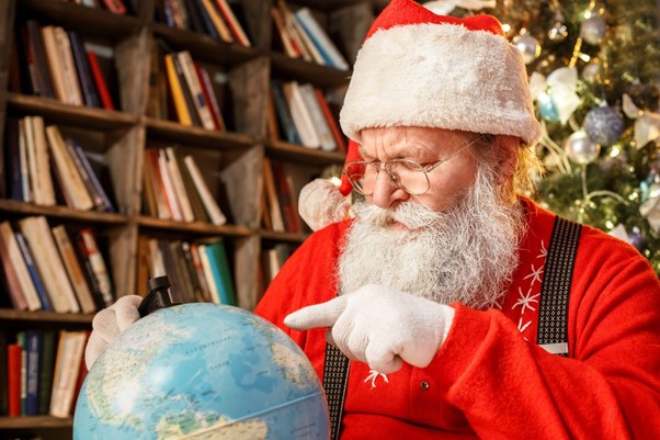 Дядо Коледа търси дестинация на глобус.