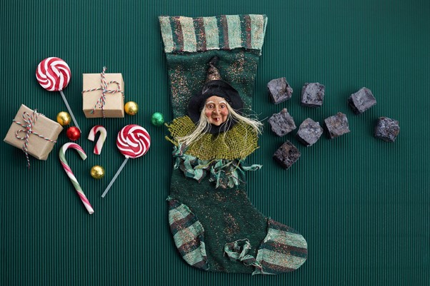 Вещицата Ла Бефана с чорап и сладкиши на заден план.