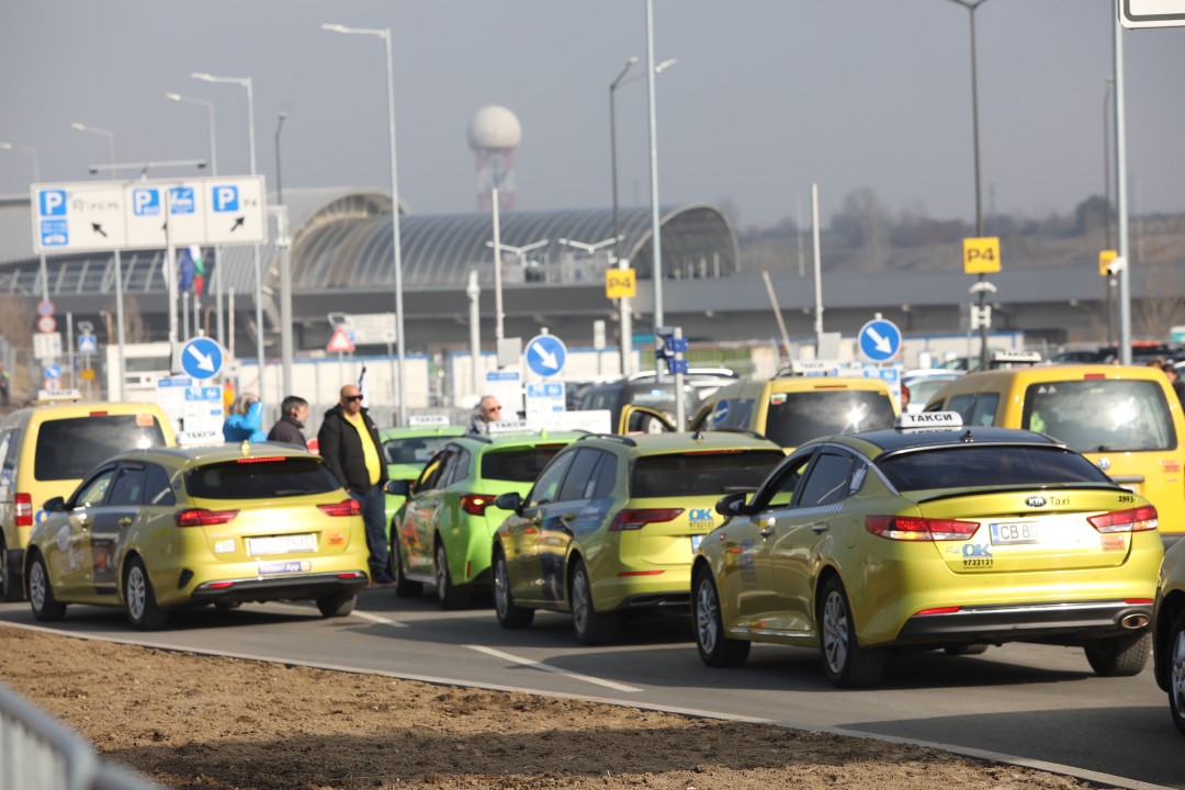 <p>Протестиращи таксиметрови шофьори се струпаха в района на Терминал 2 на летище София. От аеропорта предупредиха пътниците да си дадат повече време и да пристигнат на летището поне 3 часа преди конкретния полет. Таксиметровите шофьори от Национален таксиметров синдикат недоволстват от новата организация на движението на аеропорта.</p>