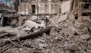 Украински военнослужещи проверяват нанесените щати след руска въздушна атака, при която е била разрушена сграда в Киев