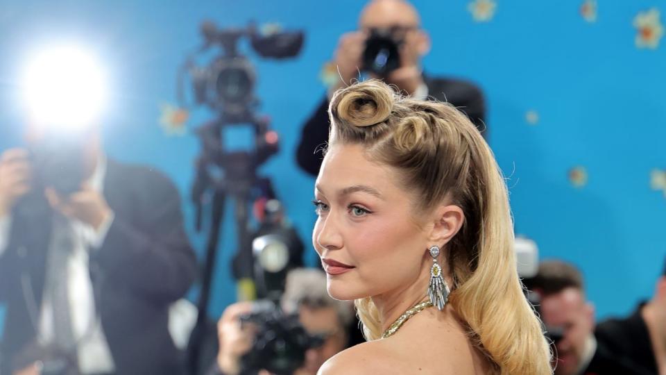 Ослепителната златна рокля Miu Miu на Джиджи Хадид е създадена в сътрудничество с Габриела Карефа-Джонсън, бивш моден редактор на Vogue и първата чернокожа жена, стилизирала корица на Vogue. Визията е вдъхновена от пионерския моден дизайнер Зелда Уин Валдес.