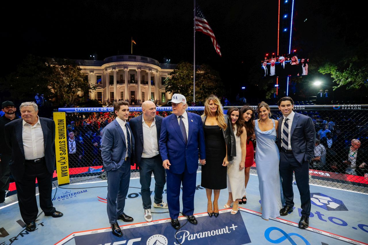 <p>Първата дама Мелания Тръмп пристигна за ММА мачовете от веригата UFC, организирани за рождения ден на президента Доналд Тръмп с кожено якде, което носеше по своя запазен начин &ndash; наметнато върху раменете. Военен ескорт вървеше редом с нея, докато тя преминаваше по Южната морава.</p>