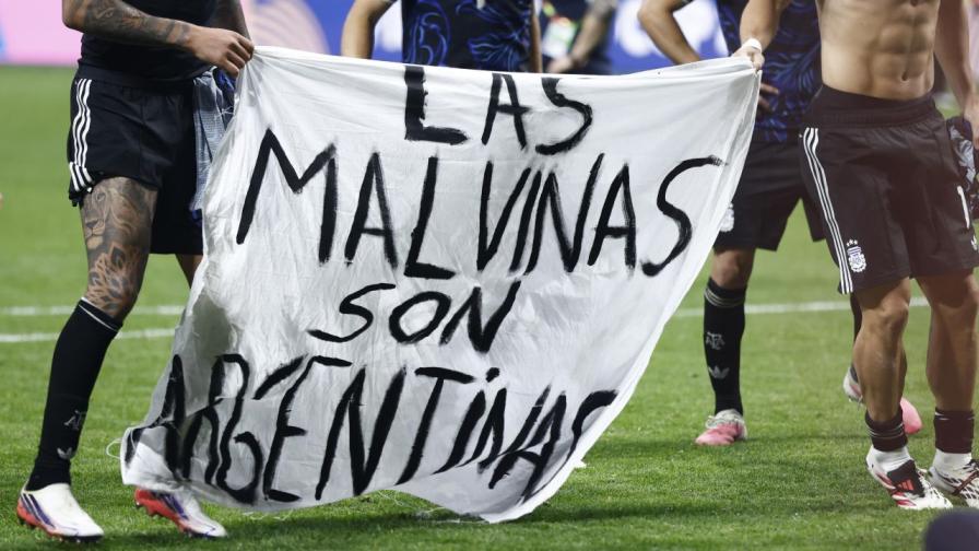 Играчи на Аржентина държат банер с надпис „Las Malvinas son Argentinas“, което се превежда като „Фолкландските острови са аржентински“