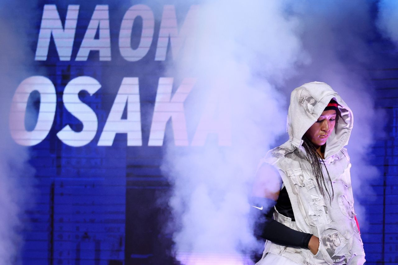 <p>Четирикратната шампионка от Големия шлем шокира феновете на US Open с роба от вестникарски заглавия и екип в стил Алън Айвърсън. Японката премина през труден мач срещу Захарова и обеща още модни изненади в следващия кръг.</p>