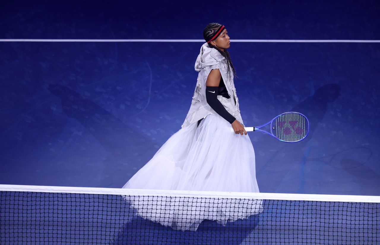 <p>Четирикратната шампионка от Големия шлем шокира феновете на US Open с роба от вестникарски заглавия и екип в стил Алън Айвърсън. Японката премина през труден мач срещу Захарова и обеща още модни изненади в следващия кръг.</p>