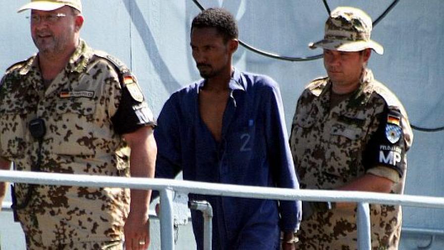 Германски военни ескортират заподозрян в пиратство сомалиец.