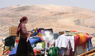 Еврейска заселничка се изнася от незаконно селище на Западния бряг, което трябва да бъде евакуирано.