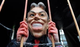 Такъв е това заслужава Тони Блеър според протестиращите пред сградата, в която се проведе изслушването