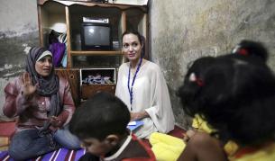 Анджелина с иракчанка и семейството й в бежански лагер в Дамаск през 2009 г.