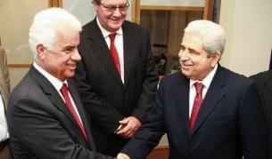 Дервиш Ероглу (вляво) и Димитрис Христофиас се ръкуват по време на среща в Никозия през май